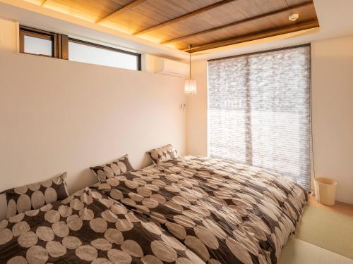 京都Family Inn Kei 慶的一间卧室设有一张大床和大窗户