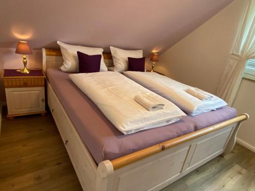 翁德洛Haus Petersen的一张配有白色床单和紫色枕头的大床