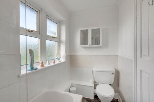 EarlhamGuest Homes - The Lodge的白色的浴室设有卫生间和水槽。