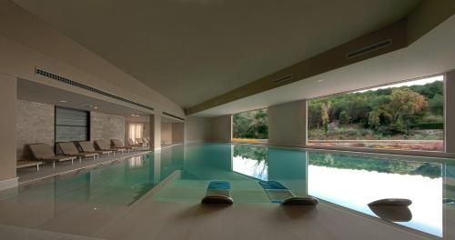 奥特朗托Basiliani - CDSHotels的大型游泳池设有两把椅子和两扇窗户
