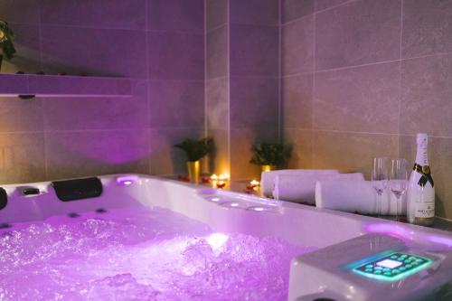 奥西耶克SAVOY residence的紫色浴室,配有一个装满紫色液体的浴缸