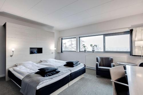 锡尔克堡锡尔克堡造纸厂丽笙酒店的一间卧室配有一张床、一张桌子和一把椅子