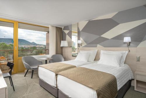 布达佩斯Ensana Thermal Margaret Island的酒店客房设有一张床和一个阳台。