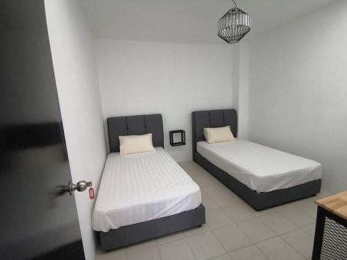 甘孟MODERN , SPACIOUS GAMBANG UMP 18 Guest House的两张位于一间可打开门的房间内的床