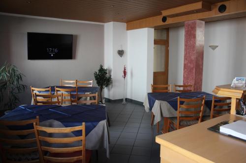 穆特尔斯塔特露丝旅馆的餐厅设有桌椅和墙上的电视