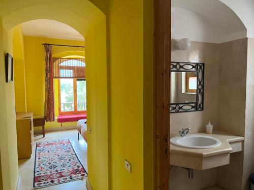 赫尔格达El Gouna, Red Sea, Egypt, West Golf 2 Bedroom Flat的黄色的浴室设有水槽和镜子