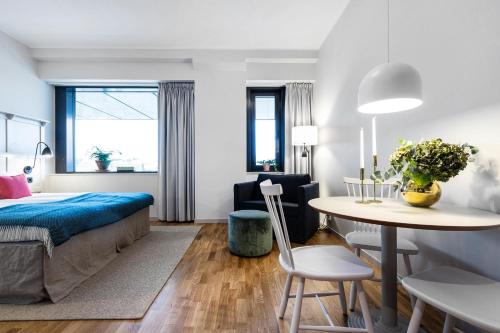 斯德哥尔摩Biz Apartment Bromma的卧室配有一张床和一张桌子及椅子