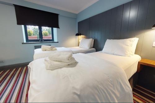 奇德尔曼彻斯特钱德尔乡村酒店的两张位于酒店客房的床,配有毛巾