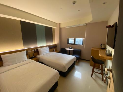 屏东县富光商旅的酒店客房配有两张床和一张书桌