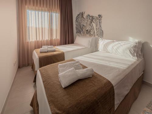 贝尼卡洛Las Cebras Apartamentos Turísticos的酒店客房,配有两张带毛巾的床