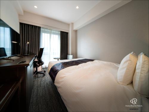 熊本Daiwa Roynet Hotel Kumamoto的酒店客房配有一张床、一张书桌和一台电脑