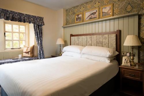 巴森斯韦特The Pheasant Inn - The Inn Collection Group的卧室设有一张白色大床和一扇窗户。