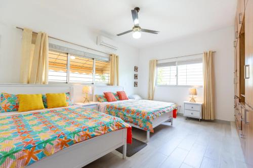 MatancitaVilla Alida Nagua Pool Beach Dailymaid & Bbq的一间卧室配有两张床和吊扇