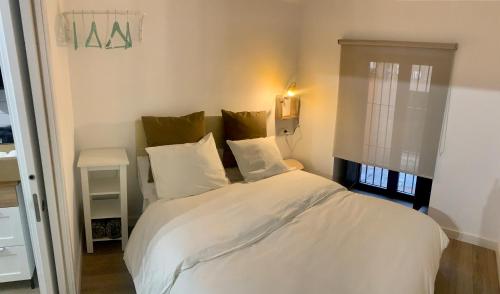 卡塞雷斯PUERTA DE CACERES Apartamento 2的一间卧室配有带白色床单和枕头的床。