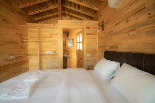 GeyikbayırıAlpstar Camping & Restaurant的木制客房内的一张大白色床