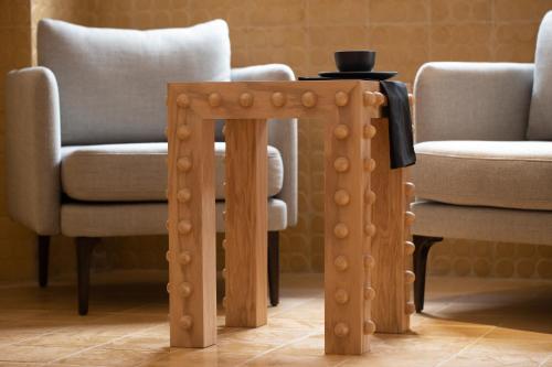 塔斯科·德·阿拉尔孔William Hotel Boutique De Diseño的客厅配有一张木桌和两把椅子