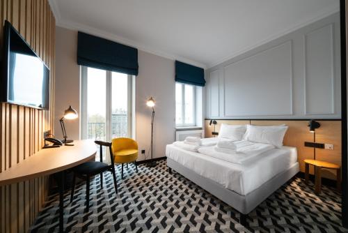华沙Hotel Tulip Residences Warsaw Targowa的酒店客房设有一张床、一张书桌和窗户。