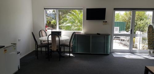 旺阿雷Affordable, Spacious, Bright, Warm, Unit in Central Whangarei的配有桌椅和电视的客房