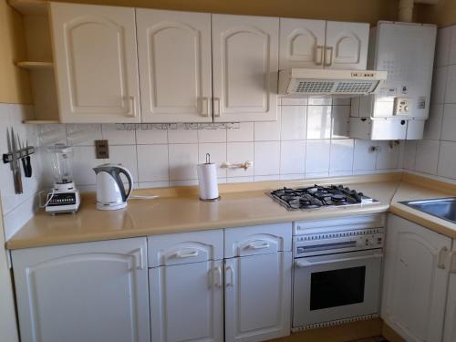 特木科Departamento Temuco Thiers的厨房配有白色橱柜和炉灶烤箱。