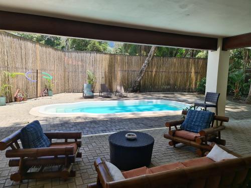 多米尼克Hona Beach Hotel的庭院设有带椅子和桌子的游泳池