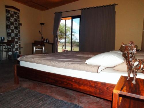 OkazizeOvita Wildlife Restcamp的一间卧室设有一张大床和窗户