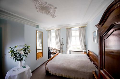 海德堡高登赫克特酒店的一间卧室,配有一张床和花瓶