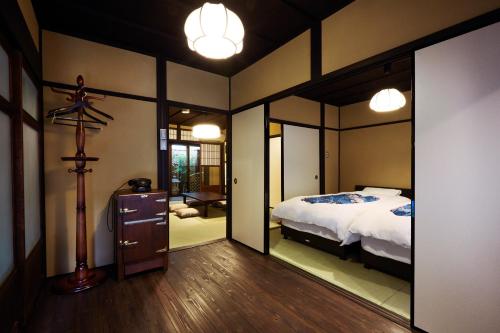 京都铃九条藤木邸东度假屋的一间卧室配有一张床和一面大镜子