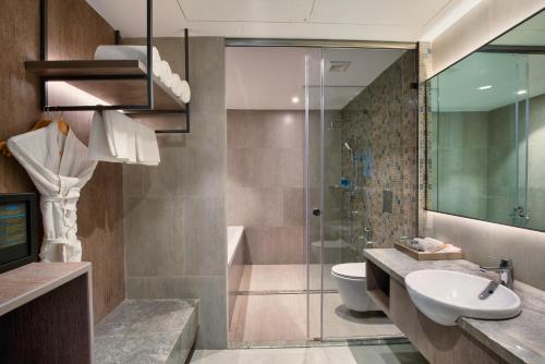 曼德姆Amoravida By 7 Apple Resorts, Goa的带淋浴、盥洗盆和卫生间的浴室