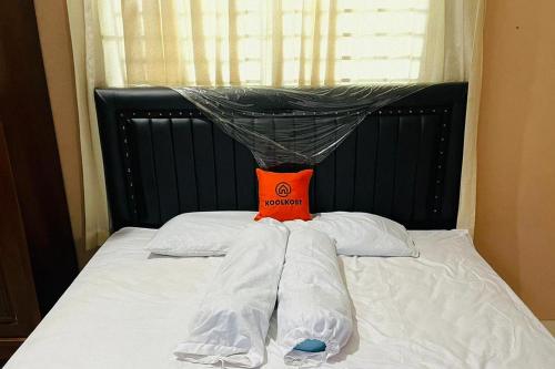 棉兰KoolKost @ Jalan Polonia Medan (Minimum Stay 6 Nights)的一张带黑色床头板和白色枕头的床
