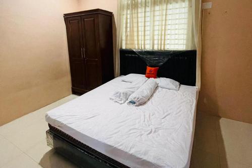 棉兰KoolKost @ Jalan Polonia Medan (Minimum Stay 6 Nights)的一间卧室配有一张带白色床单的床和一扇窗户。