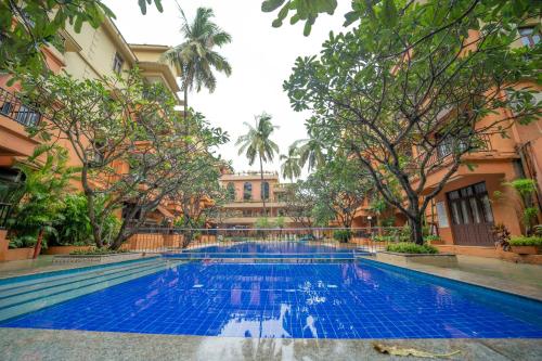 卡兰古特奈朗斯大酒店的一座位于庭院的游泳池,庭院里种有树木,大楼里