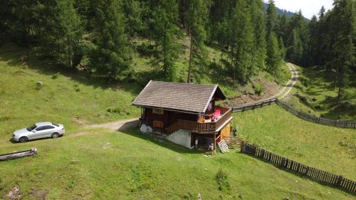 海利根布卢特Ferienhütte Ortnerkasa的山丘上的小房子,旁边有一辆车