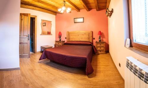 Muñogalindocasa rural La Gabina的一间卧室配有一张床,铺有木地板