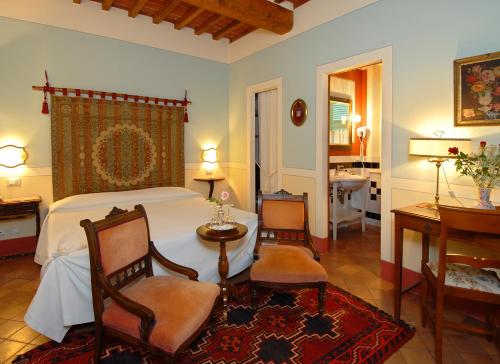 蒙特普齐亚诺伊尔荣多精品酒店的一间卧室配有一张床、两把椅子和一张桌子