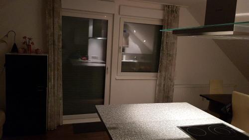 曼海姆Joanna Apartment - MA Rheinau 5的一间设有玻璃门的房间和一张桌子,桌子上配有gmaxwell gmaxwell gmaxwell gmaxwell
