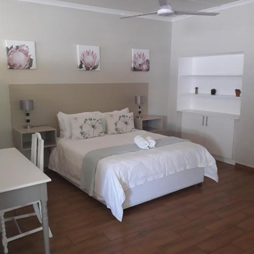 哈博罗内Aflica Apartments的一间卧室配有带白色床单和枕头的床。
