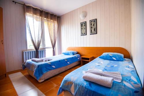 拉兹洛格Семеен Хотел Надежда的一间卧室配有两张带毛巾的床