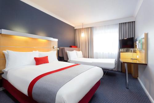 南安普敦快捷假日南安普敦M27高速公路7号岔口酒店的酒店客房设有两张床和窗户。