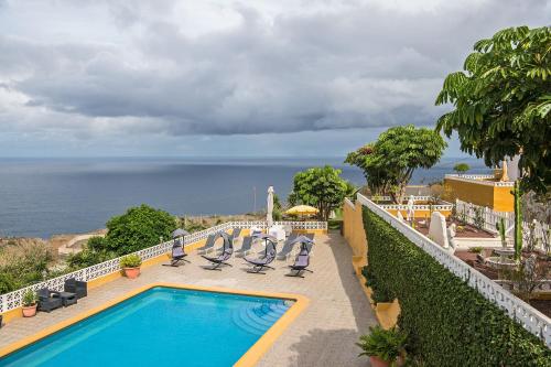 San Juan de la RamblaApartment La Gomera II的一个带椅子的游泳池,背景是大海