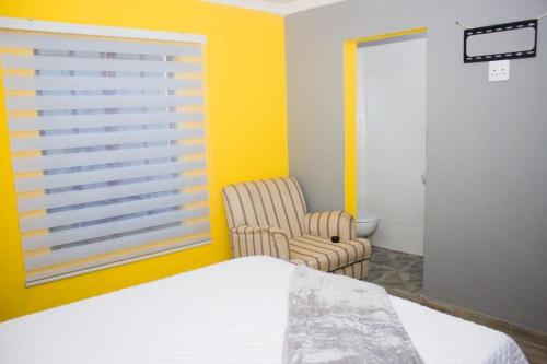 索韦托Rukza's Guest House的卧室配有床、椅子和窗户。