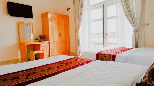 大叻Villa Trung Nghĩa 30的酒店客房设有两张床和窗户。
