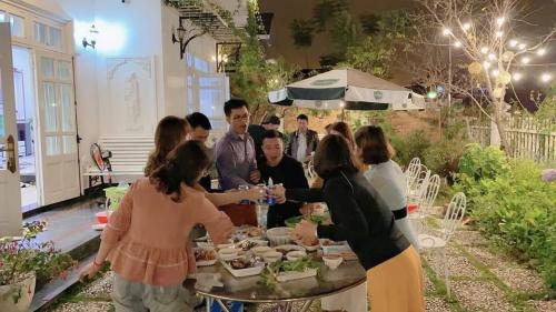 大叻Villa Trung Nghĩa 30的一群人站在桌子旁吃着食物