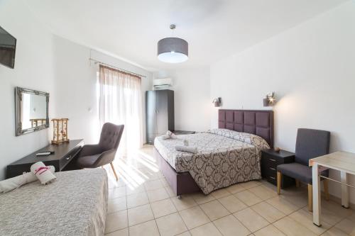 法里拉基亚尼利亚精品公寓酒店的一间卧室配有两张床和一张桌子及椅子