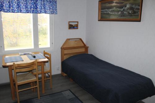 苏奥穆斯萨尔米安曼旅馆的一间卧室配有一张床、一张桌子和一张桌子