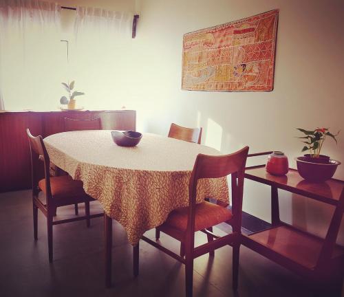 桑蒂尼盖登PARUL - Elegant Heritage Home at the Heart of Shantiniketan的餐桌、椅子和白色桌布