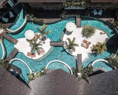 塞米亚克Beyond Bayou的享有带桌子和棕榈树的游泳池的顶部景致