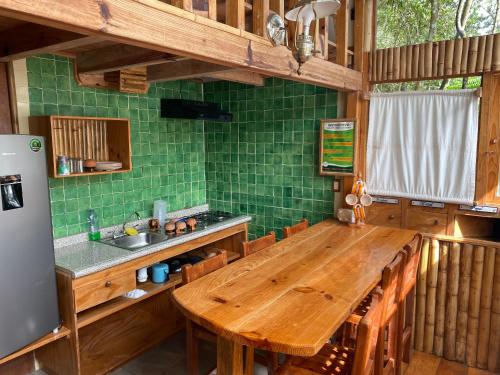 库埃察兰德尔普罗格雷索Cabañas Aldea San Francisco de Asís的厨房配有木桌和绿色瓷砖