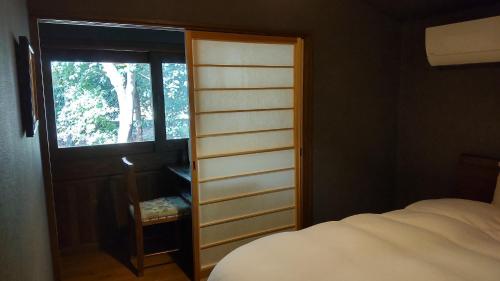 Taragivilla YUUNOBI - Vacation STAY 78559v的一间卧室设有衣柜、一张床和一个窗户。