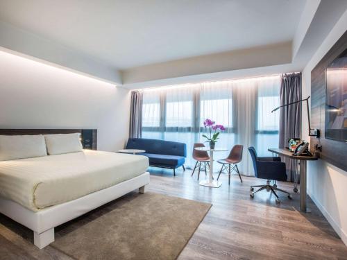 罗马诺富特罗马欧酒店的卧室配有一张床和一张桌子及椅子