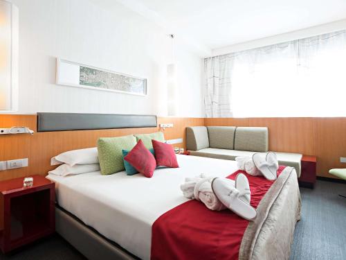 罗马诺富特罗马欧酒店的酒店客房,配有两张带毛巾的床
